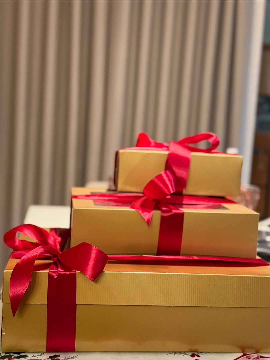 Stacked gift boxes in gold with red ribbons